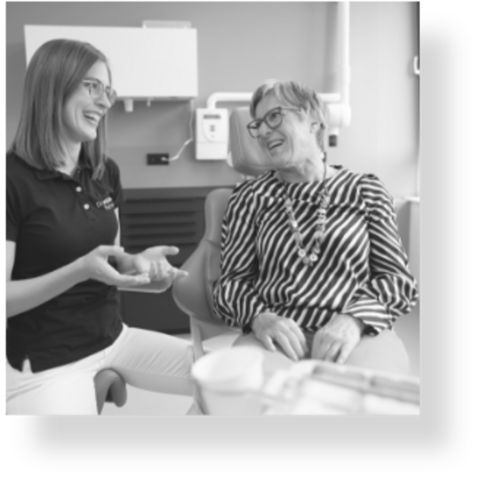 Zahnärztin Dr. Miriam Fischer und eine Patientin lachen während der Behandlung
