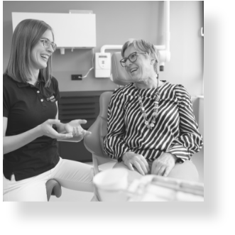 Zahnärztin Dr. Miriam Fischer und eine Patientin lachen während der Behandlung